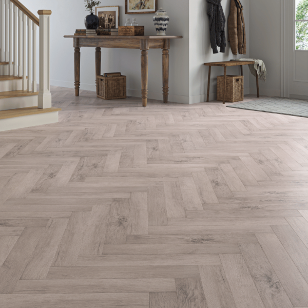 Wide room view of Dorset Herringbone Laminate Light Grey Oak flooring with soft grey tones and bevelled edges