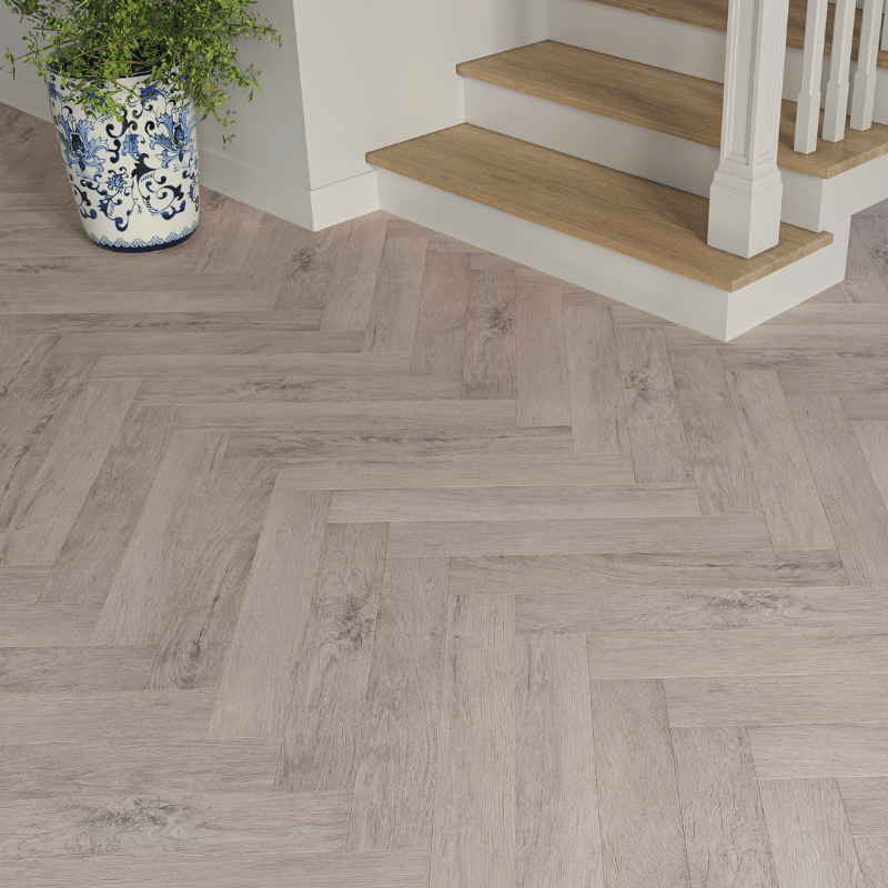 Close-up view of Dorset Herringbone Laminate Light Grey Oak plank with realistic wood grain and bevelled edges