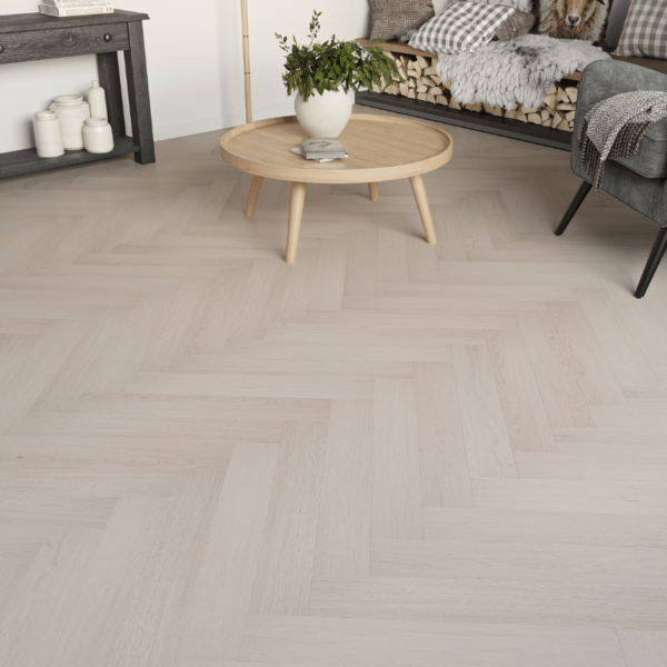 Close-up view of Prestige Herringbone 12mm Cool Oak laminate flooring, featuring realistic wood grain and bevelled edges