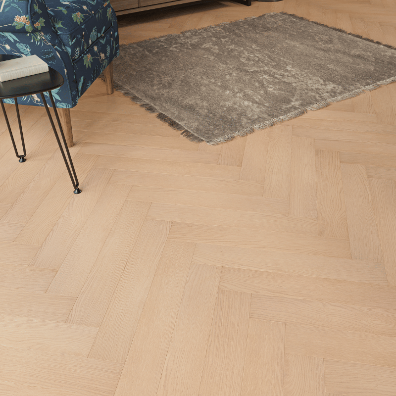 Close-up view of Prestige Herringbone 12mm Soft Oak laminate flooring, featuring realistic wood grain and bevelled edges