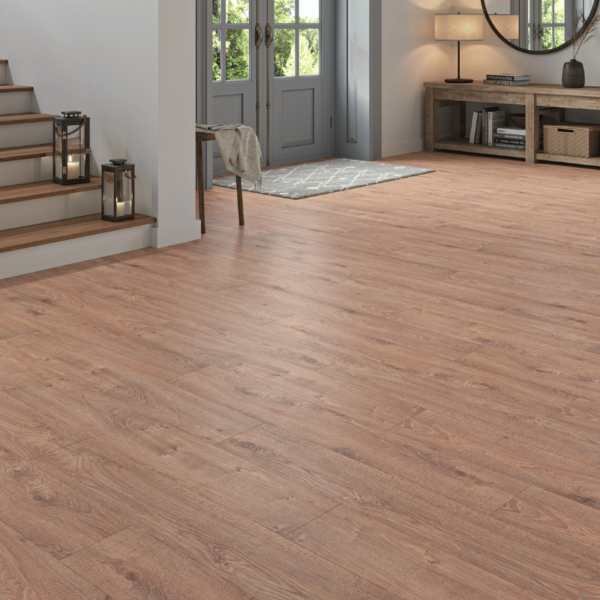 Cozy living space featuring Heritage Deluxe Laminate Warm Oak 12mm flooring with rich, golden woodgrain tones